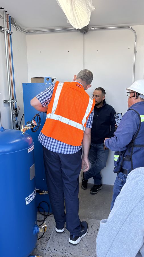 Técnicos durante el arranque de un generador de nitrógeno en el cuarto de compresores de un cliente