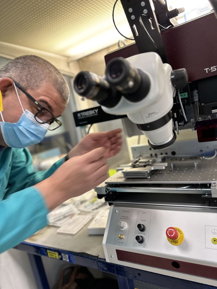 Técnico operando un die bonder Tresky con microscopio para colocación de chips