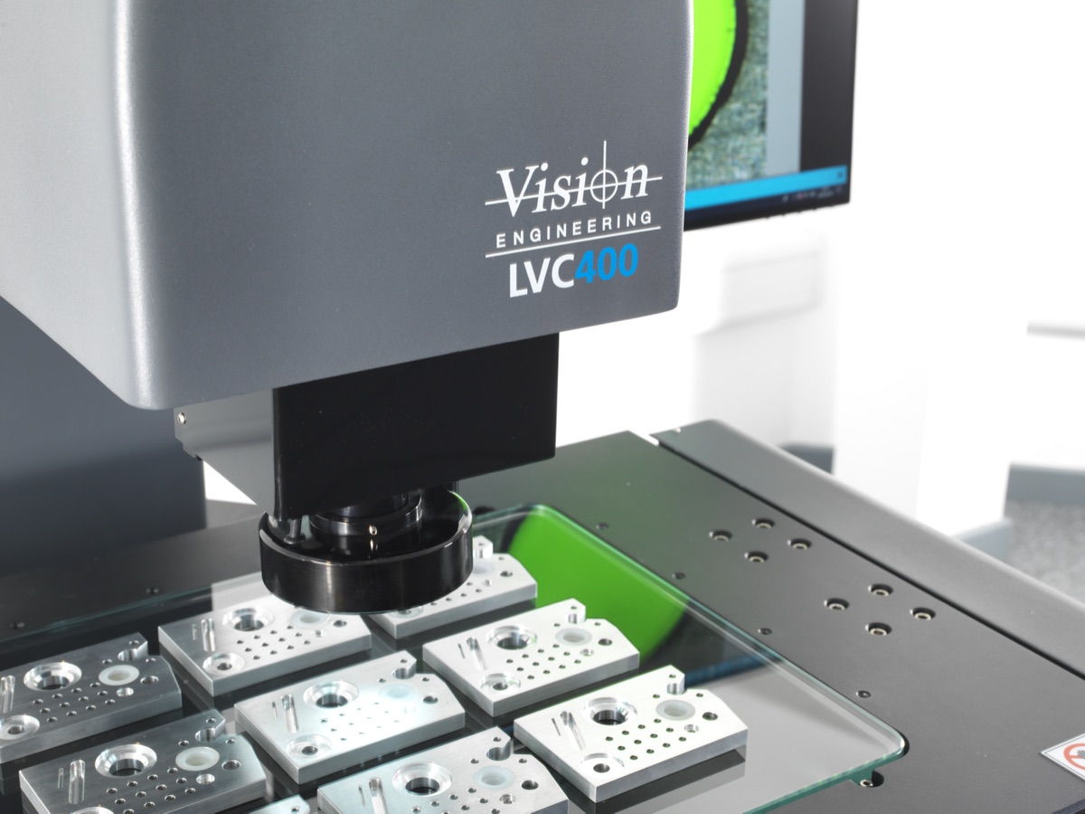Cabezal del sistema de medición por video LVC400 de Vision Engineering sobre piezas maquinadas